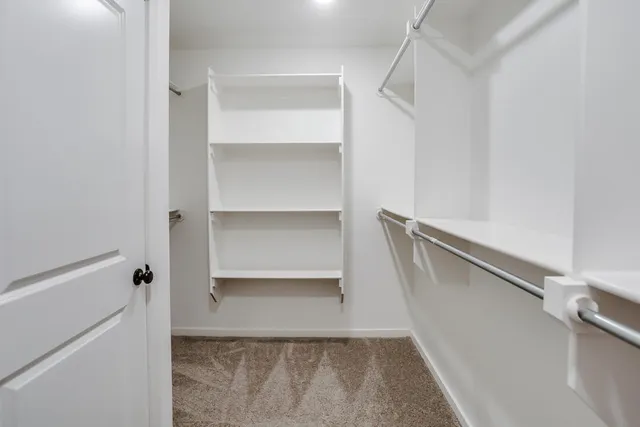 a view of walk in closet with empty racks