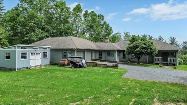 a view of a house with a yard and sitting area