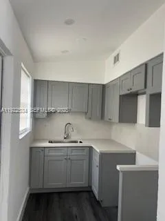 a kitchen with a sink a stove and cabinets