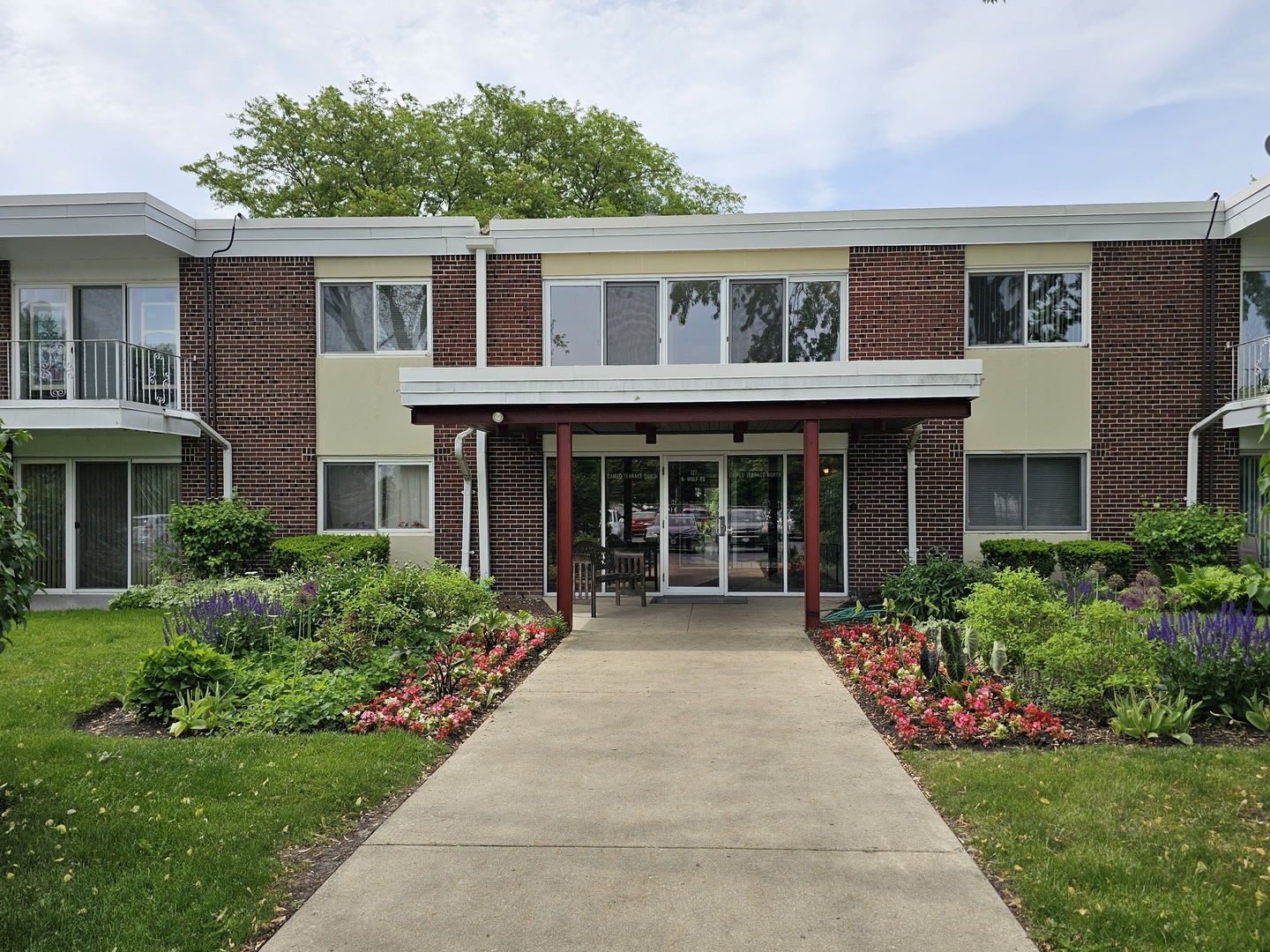 127 North Wolf Road, Unit 57B Wheeling, IL 60090 - Photo 1 of 18 a front view of a house with garden and porch