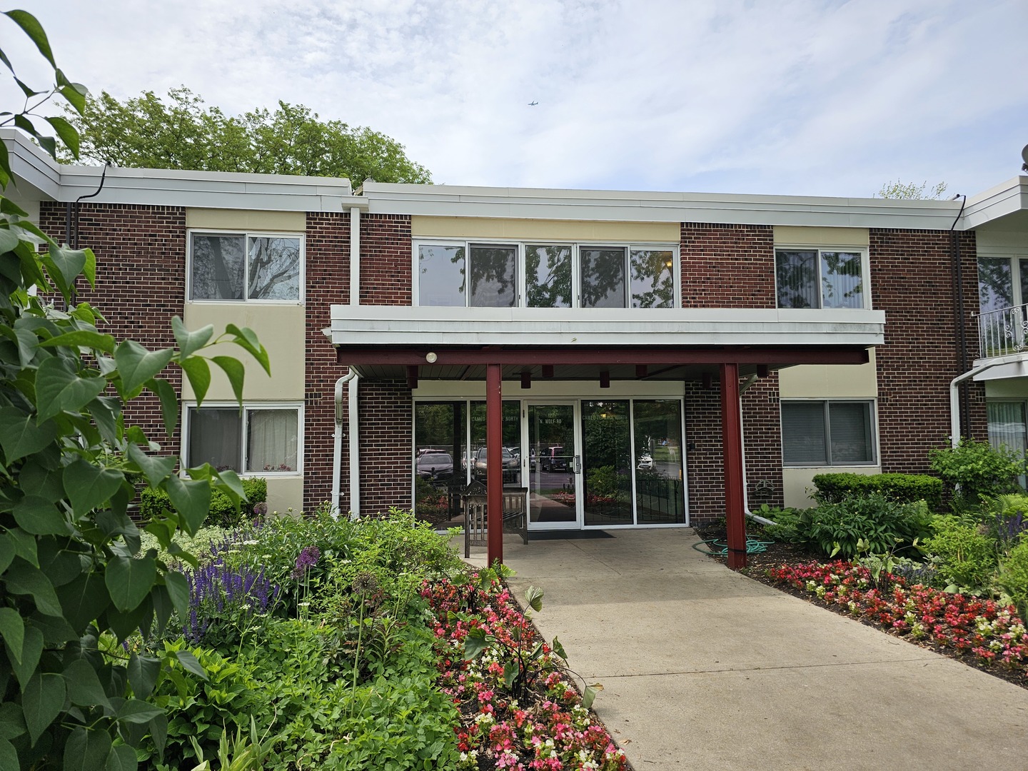 127 North Wolf Road, Unit 57B Wheeling, IL 60090 - Photo 18 of 18 front view of house with a yard and potted plants