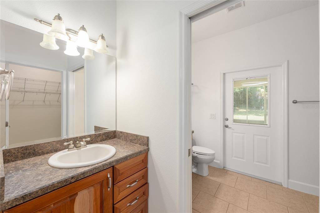4735 Southeast 112th Street Road Belleview, FL 34420 - Photo 34 of 73 a bathroom with a granite countertop sink a toilet and a mirror