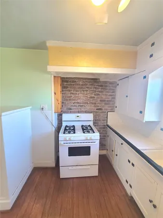 a view of a kitchen with wooden floor and electronic appliances