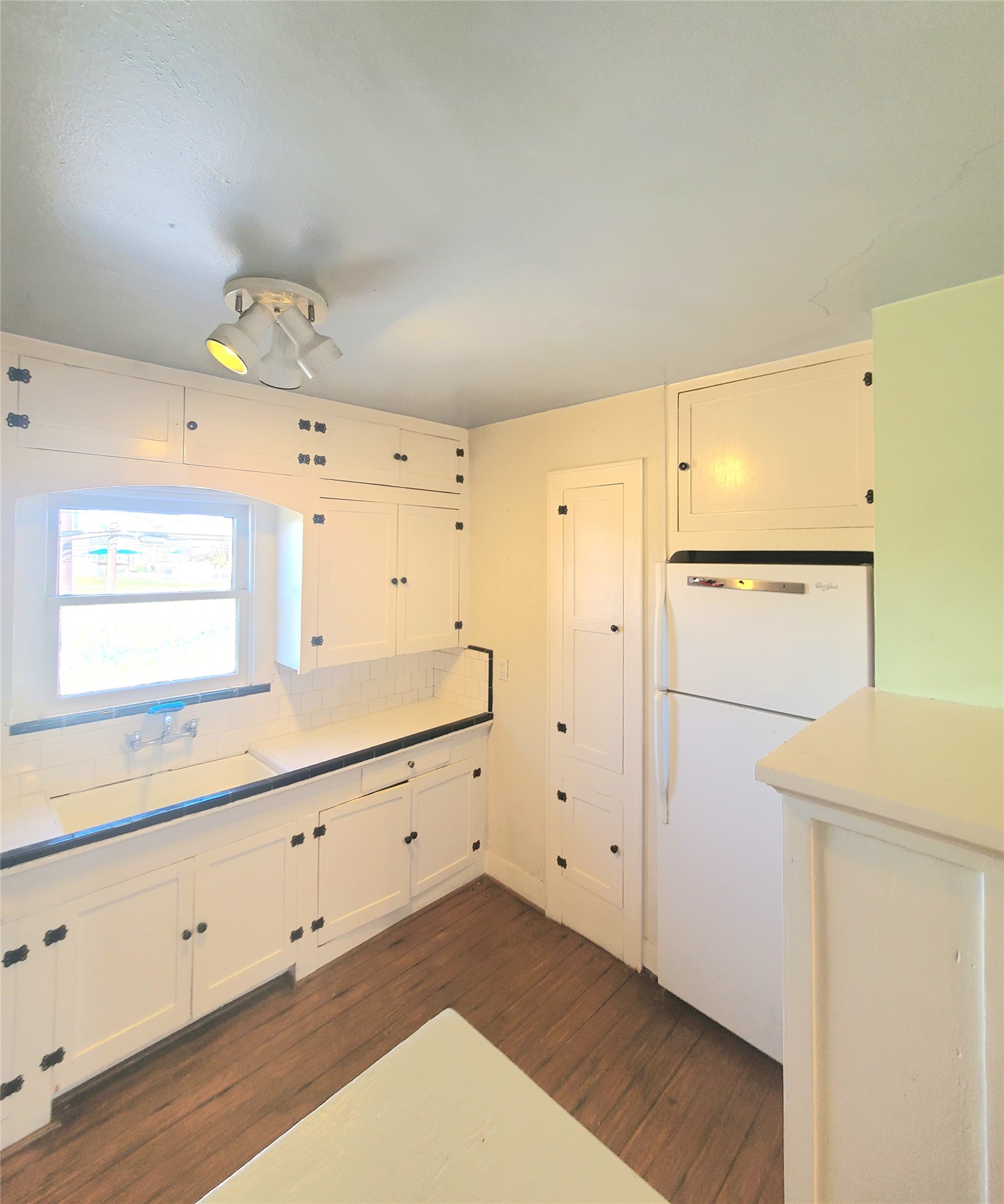 1827 Fourcade Street Houston, TX 77023 - Photo 4 of 16 a kitchen with cabinets and wooden floor