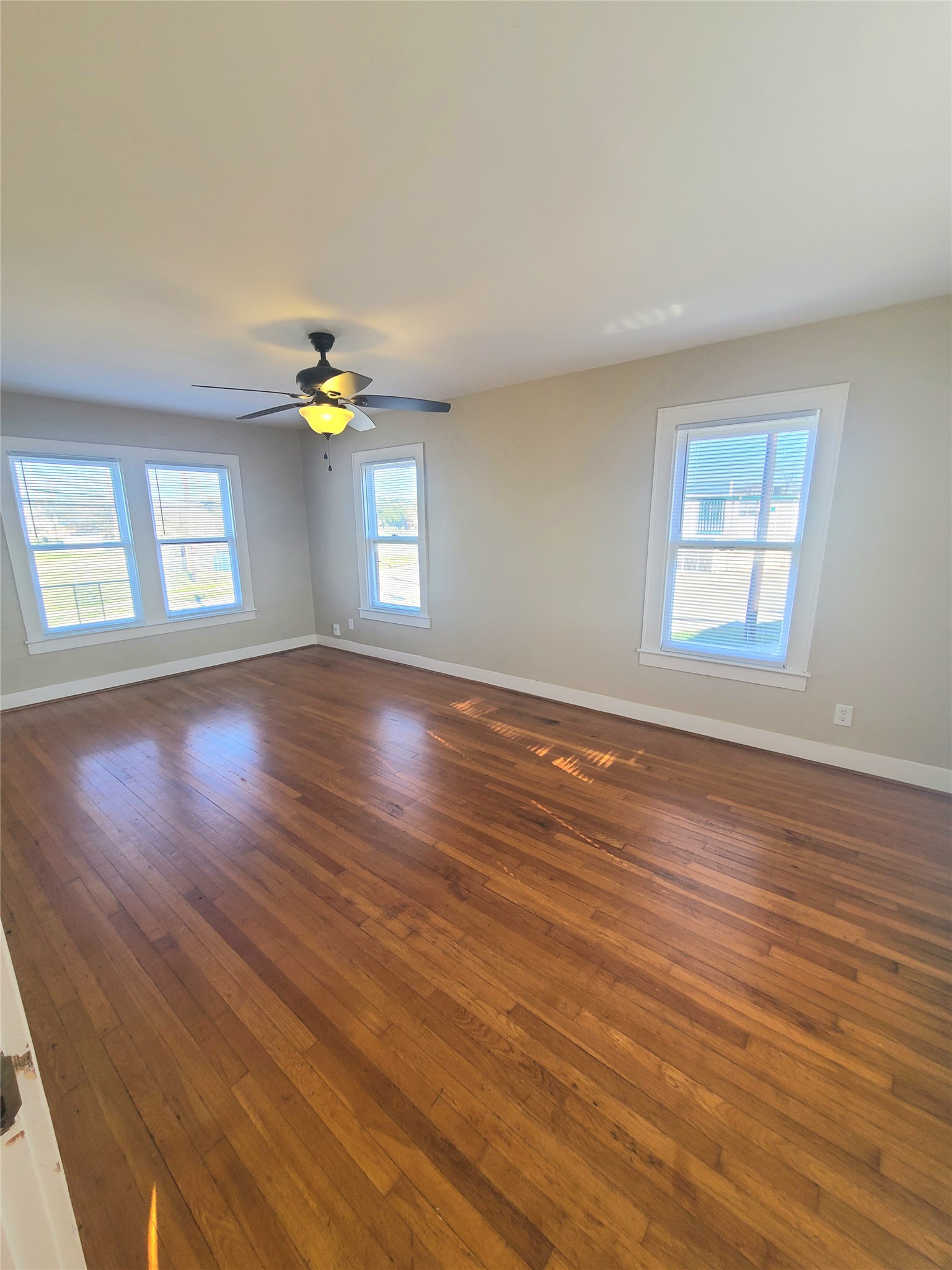 1827 Fourcade Street Houston, TX 77023 - Photo 7 of 16 a view of an empty room with wooden floor and a window