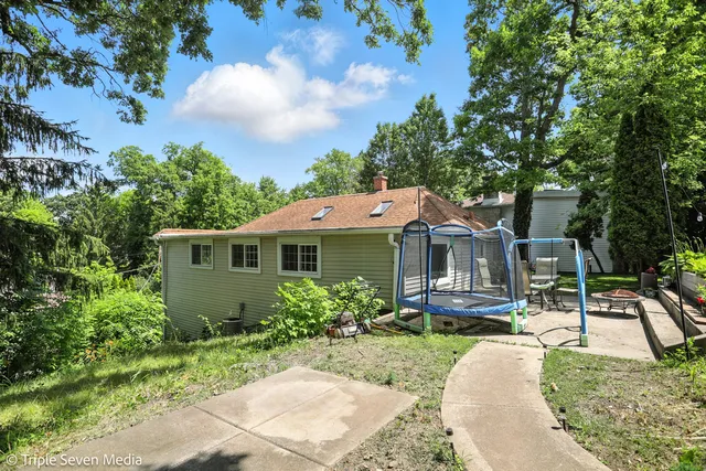 a view of a backyard with table and chairs and wooden fence