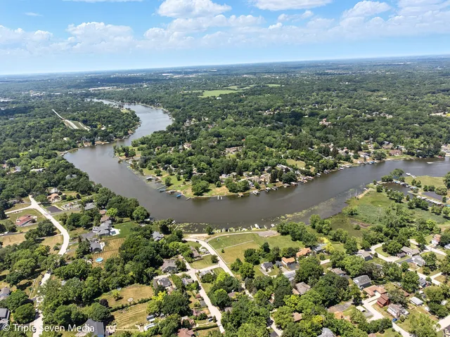 a view of a swimming pool with lawn chairs and plants