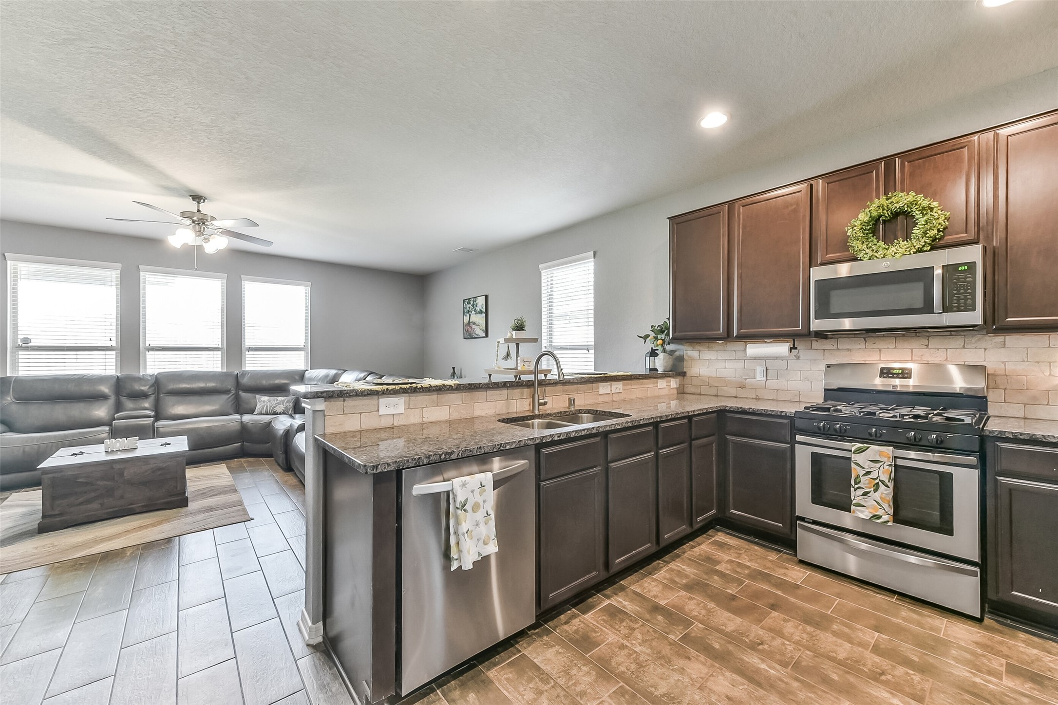 29418 Ridge Clearing Trail Spring, TX 77386 - Photo 7 of 37 a kitchen with stainless steel appliances granite countertop a stove top oven a sink dishwasher a dining table and chairs with wooden floor