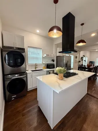 a kitchen with stainless steel appliances granite countertop a sink a stove and a wooden floors
