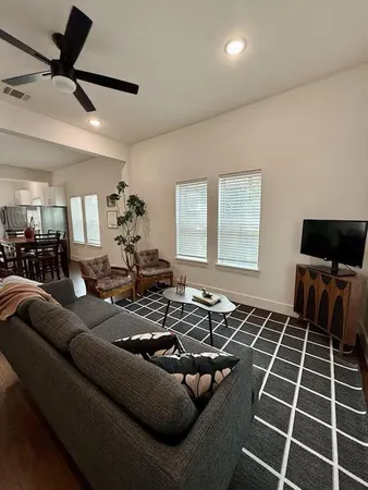 a living room with furniture a window and a flat screen tv