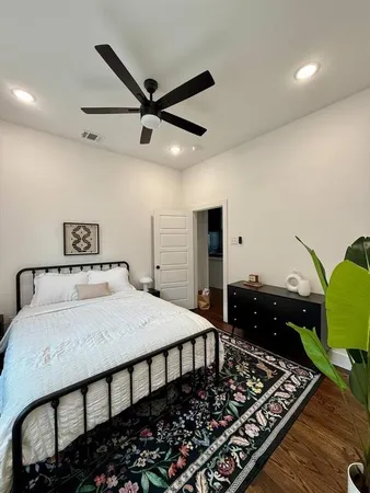 a bedroom with a bed and wooden floor