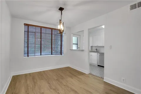 a view of empty room with wooden floor and windows