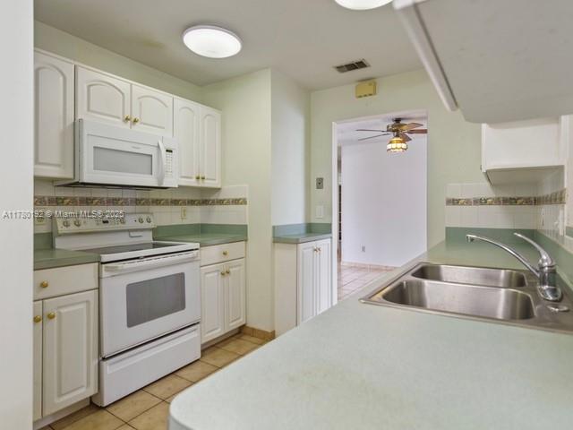 9864 Southwest 26th Terrace Miami, FL 33165 - Photo 15 of 39 a kitchen with stainless steel appliances granite countertop a sink and a stove top oven