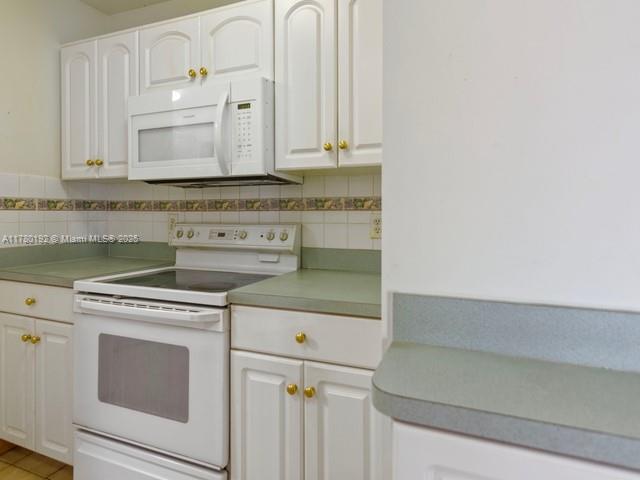 9864 Southwest 26th Terrace Miami, FL 33165 - Photo 17 of 39 a kitchen with granite countertop white cabinets and white appliances