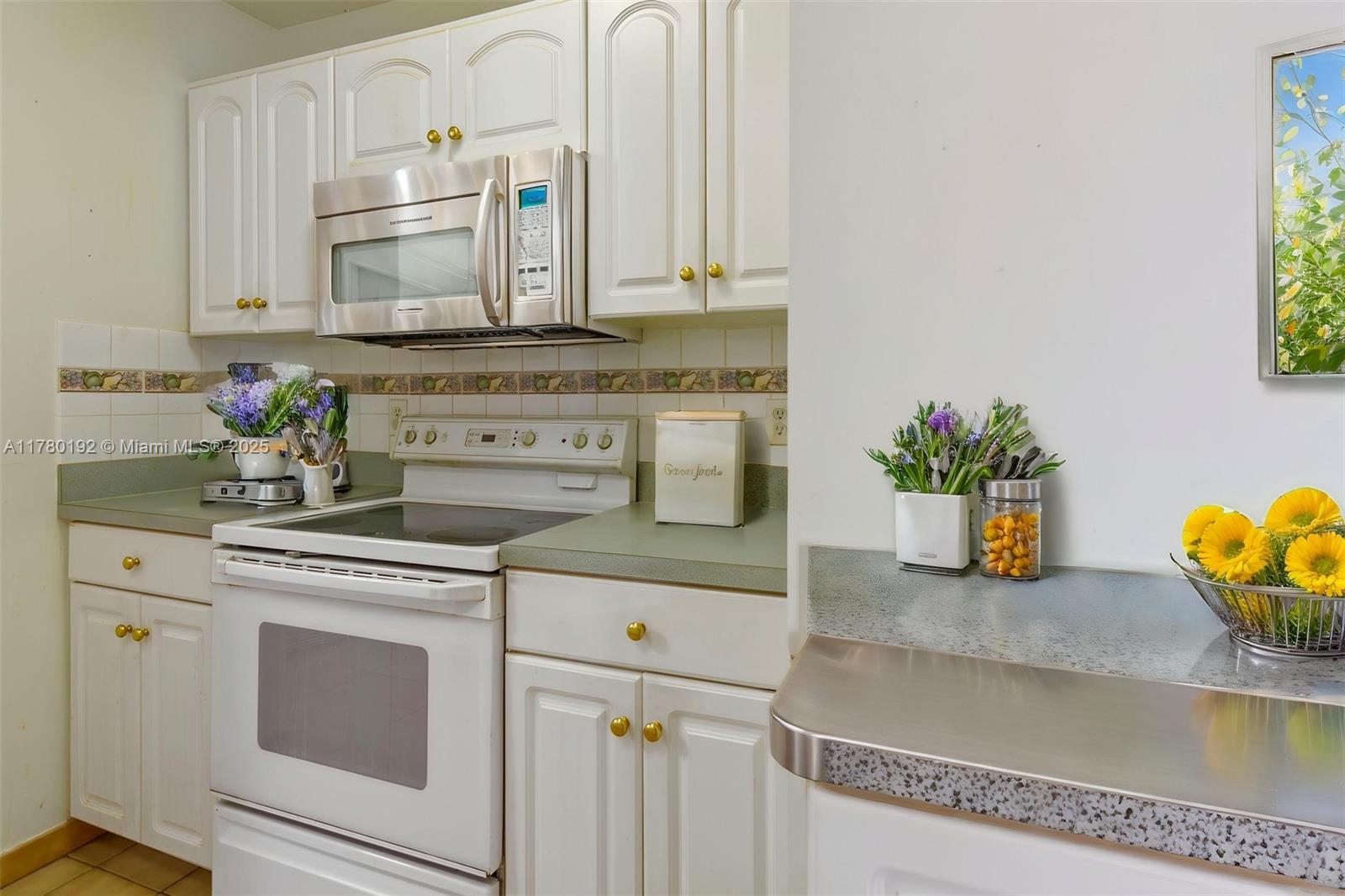 9864 Southwest 26th Terrace Miami, FL 33165 - Photo 18 of 39 a kitchen with stainless steel appliances granite countertop a sink a stove and cabinets