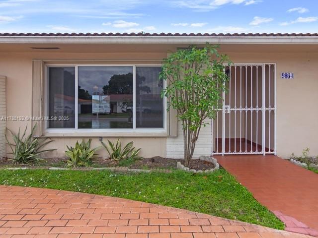 9864 Southwest 26th Terrace Miami, FL 33165 - Photo 2 of 39 a front view of a house with a garden