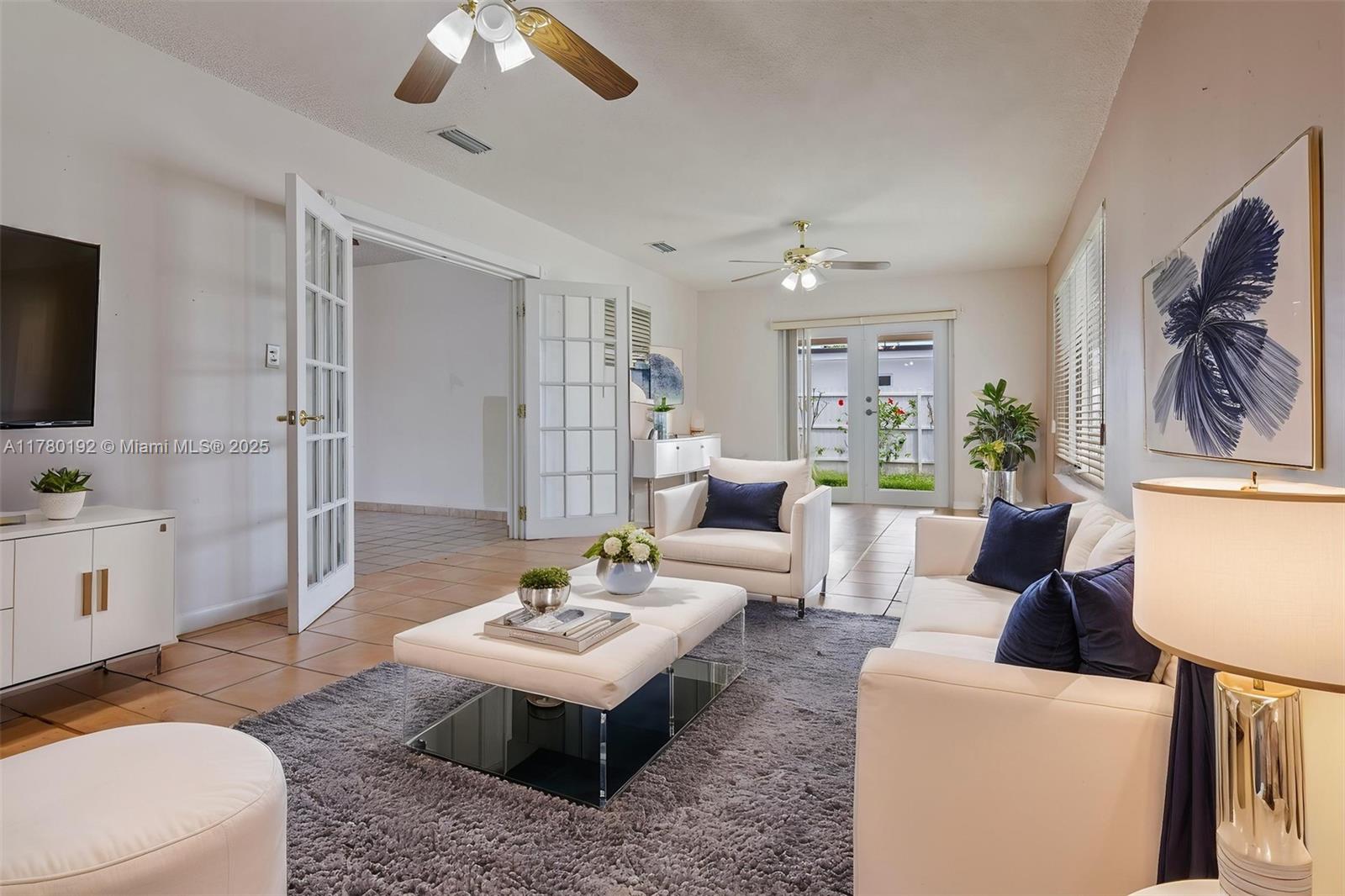9864 Southwest 26th Terrace Miami, FL 33165 - Photo 24 of 39 a living room with furniture a chandelier and a flat screen tv