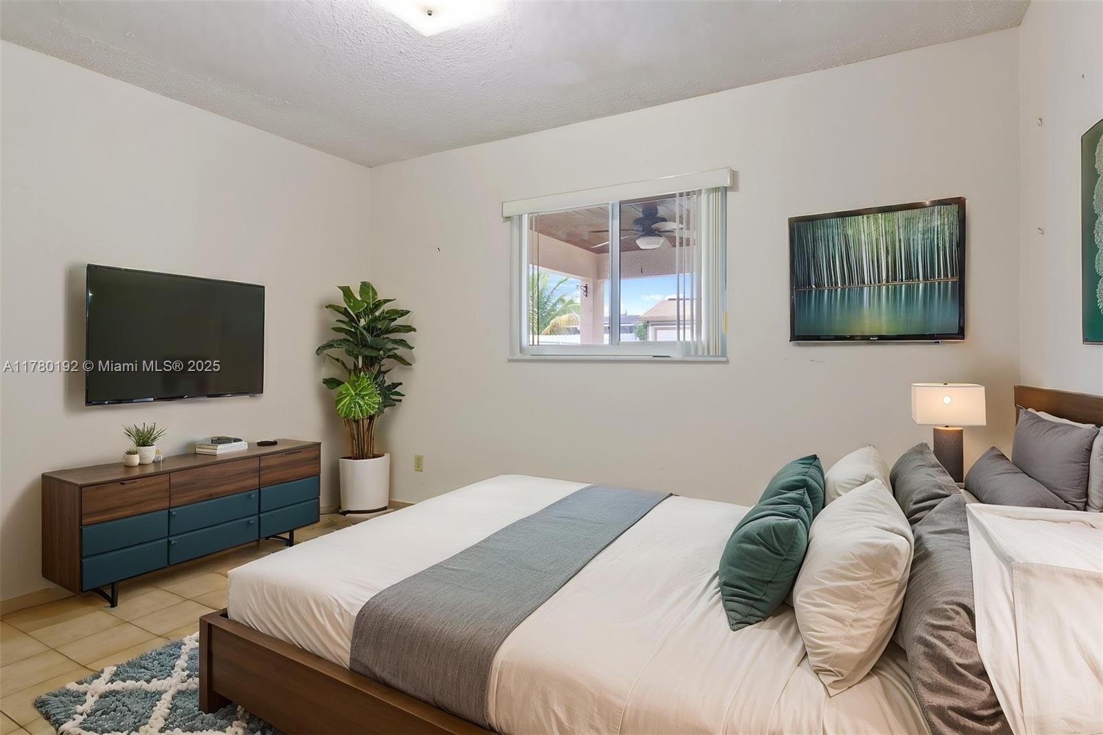 9864 Southwest 26th Terrace Miami, FL 33165 - Photo 34 of 39 a bedroom with a bed and a flat screen tv