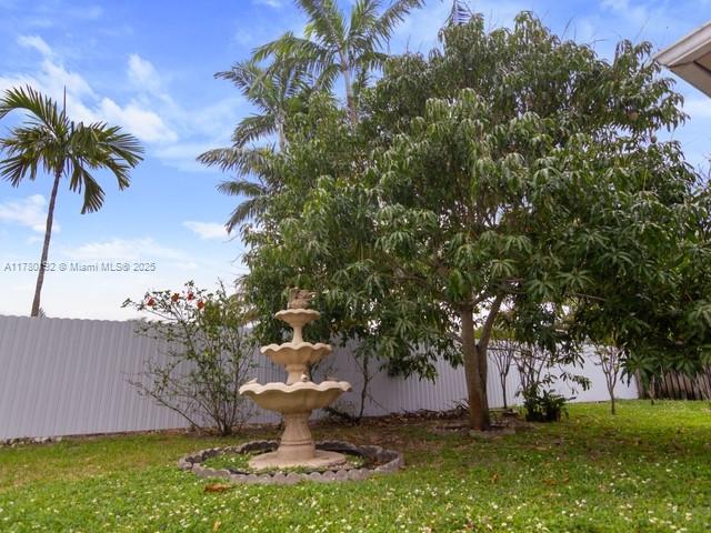 9864 Southwest 26th Terrace Miami, FL 33165 - Photo 38 of 39 a view of a fountain in front of a big yard with plants and large trees