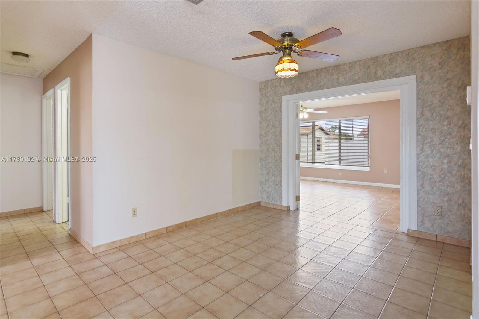 9864 Southwest 26th Terrace Miami, FL 33165 - Photo 9 of 39 a view of an empty room with a ceiling fan and window