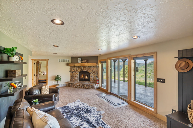 2013 North River View Road Huntsville, UT 84317 - Photo 25 of 53 Living room featuring recessed lighting, carpet floors, a textured ceiling, and a fireplace
