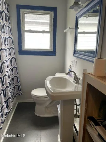 a bathroom with a toilet sink and mirror