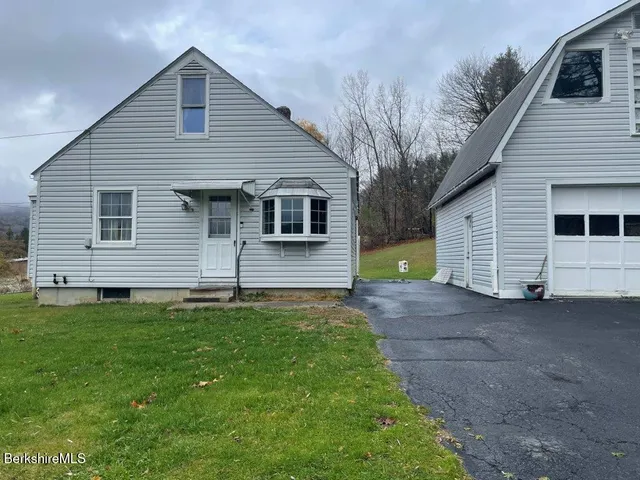 a front view of house with yard and trees