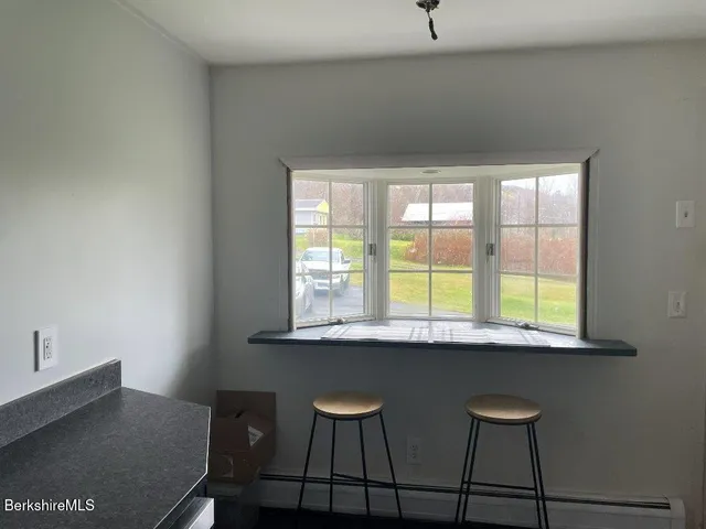 a view of a workspace with furniture and window