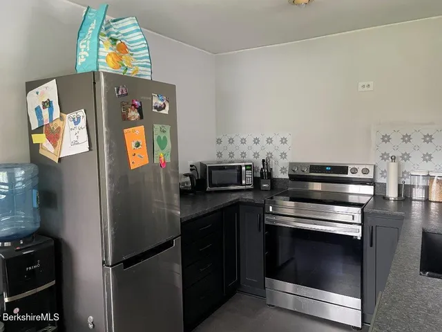 a kitchen with stainless steel appliances a stove a refrigerator and a microwave