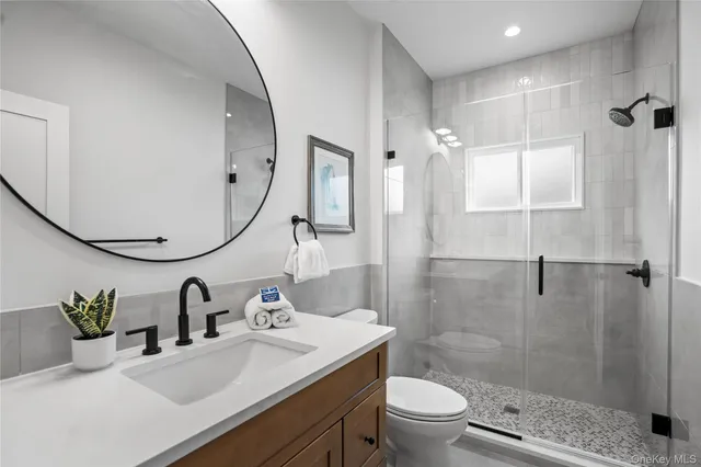 a bathroom with a sink a toilet and shower