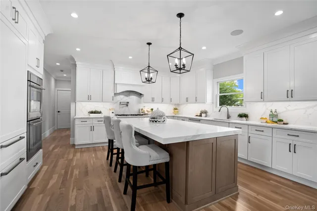 a kitchen with stainless steel appliances kitchen island granite countertop a sink a stove and a refrigerator