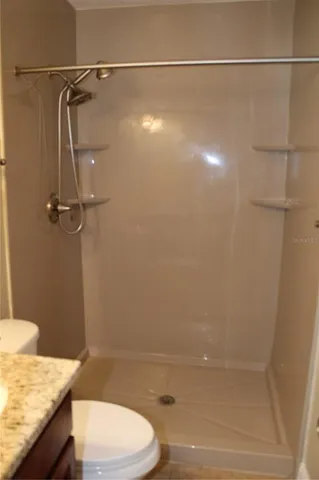 a bathroom with a granite countertop sink toilet and shower