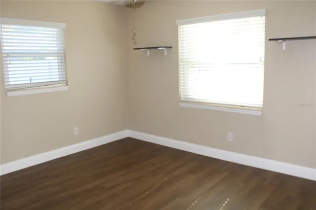 an empty room with wooden floor and a window