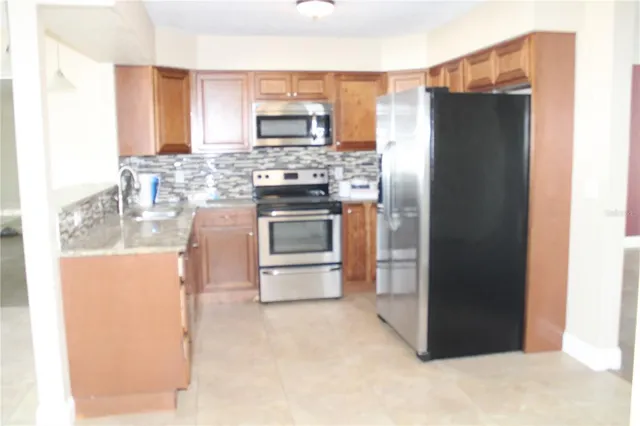 a kitchen with stainless steel appliances a refrigerator stove and sink