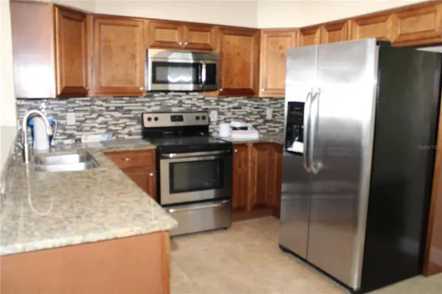 a kitchen with stainless steel appliances granite countertop a refrigerator and a stove