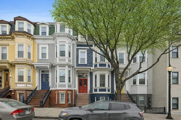 a front view of a residential apartment building with a yard