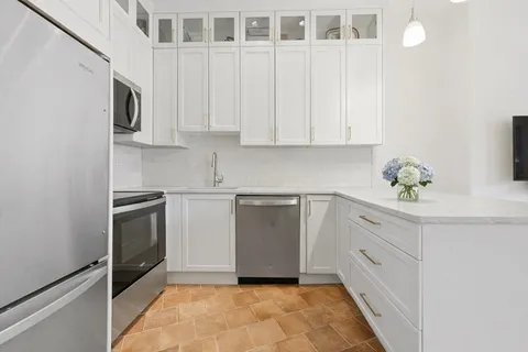 a kitchen with granite countertop white cabinets stainless steel appliances and sink