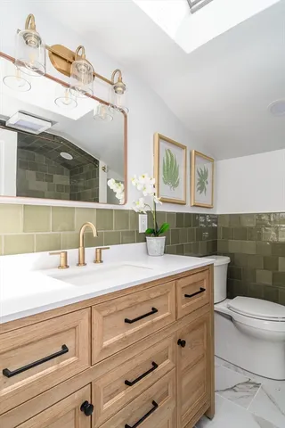 a bathroom with a sink a toilet and mirror