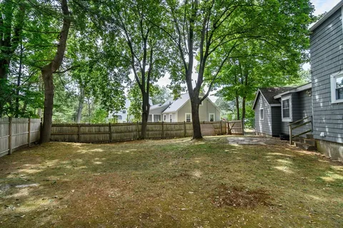 a view of a yard with a house and large trees