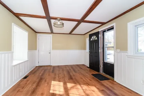 a view of a hallway with wooden floor and door