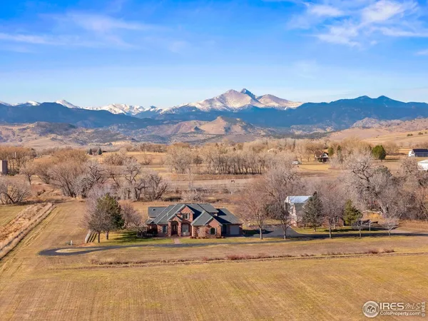 a front view of a house with a yard and a large tree