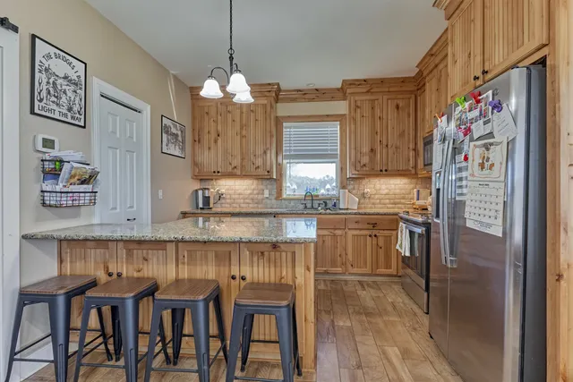 a kitchen with stainless steel appliances granite countertop a refrigerator and a stove top oven