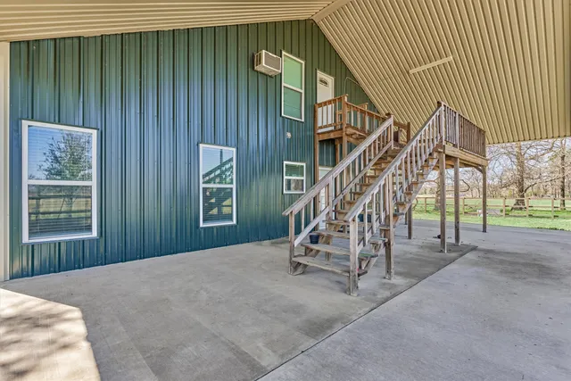 a view of an empty room with stairs and windows