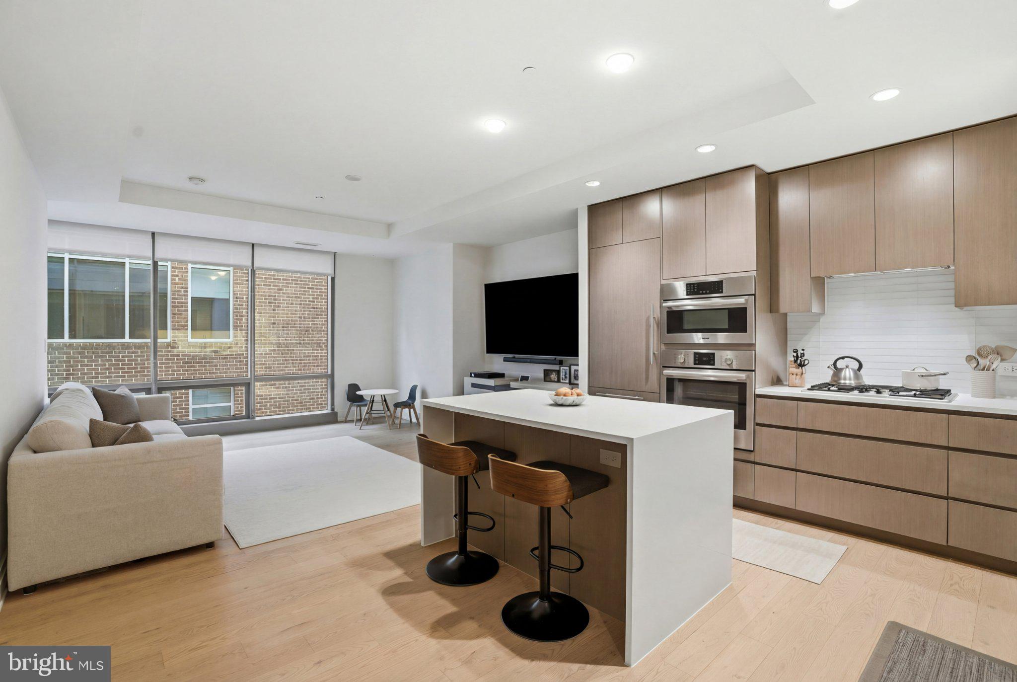 2501 M Street Northwest, Unit 209 Washington, DC 20037 - Photo 1 of 48 a living room with stainless steel appliances kitchen island granite countertop a sink and a refrigerator