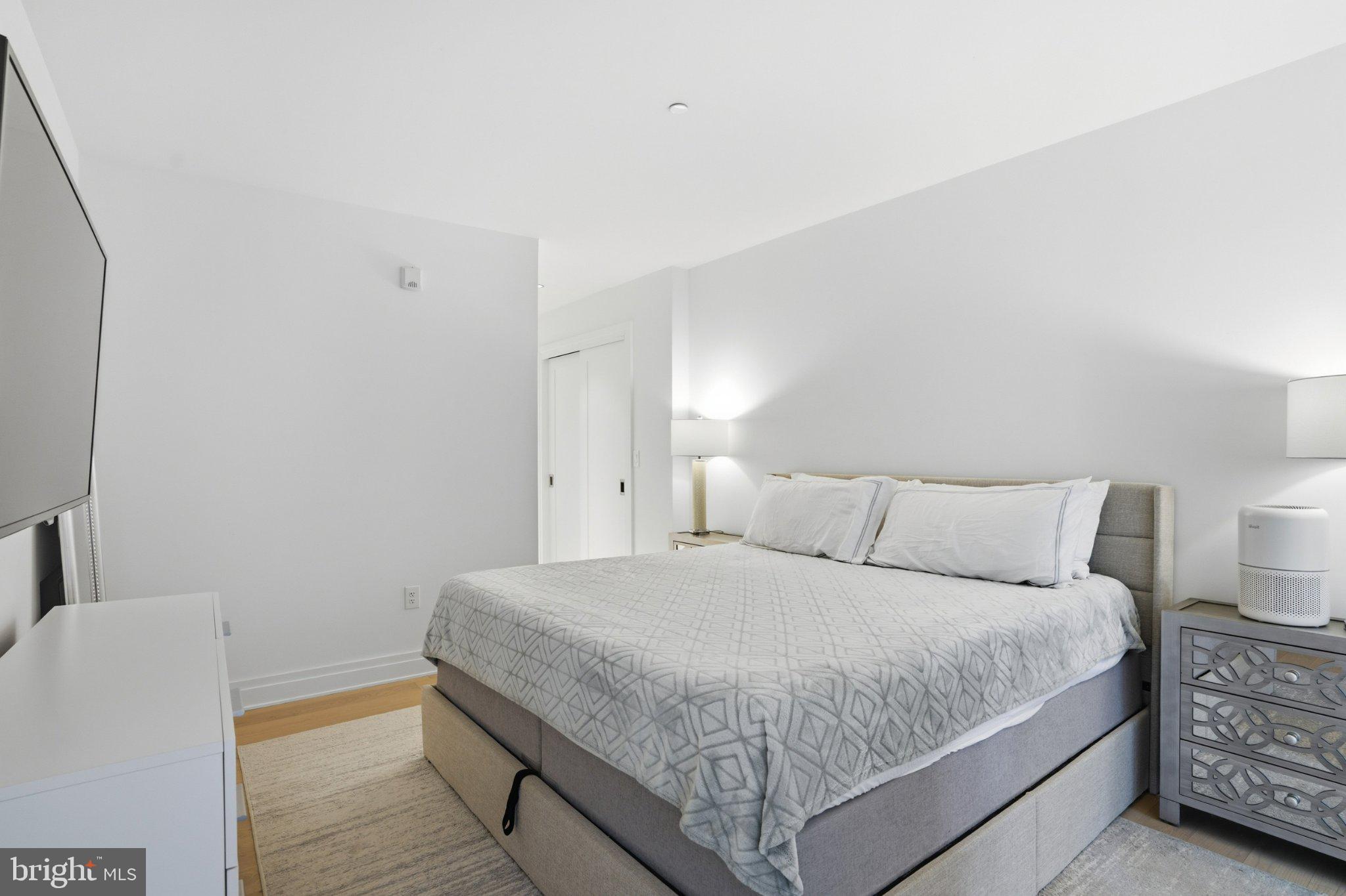 2501 M Street Northwest, Unit 209 Washington, DC 20037 - Photo 18 of 48 a bedroom with a bed and a lamp with the wall