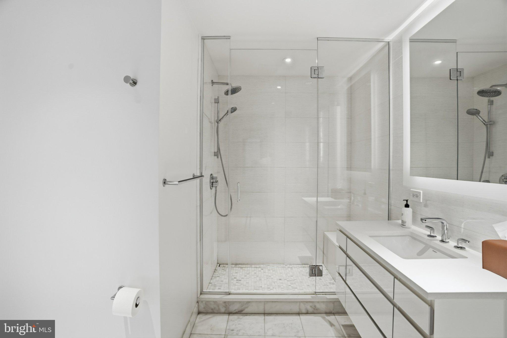 2501 M Street Northwest, Unit 209 Washington, DC 20037 - Photo 26 of 48 a bathroom with a shower sink vanity and mirror