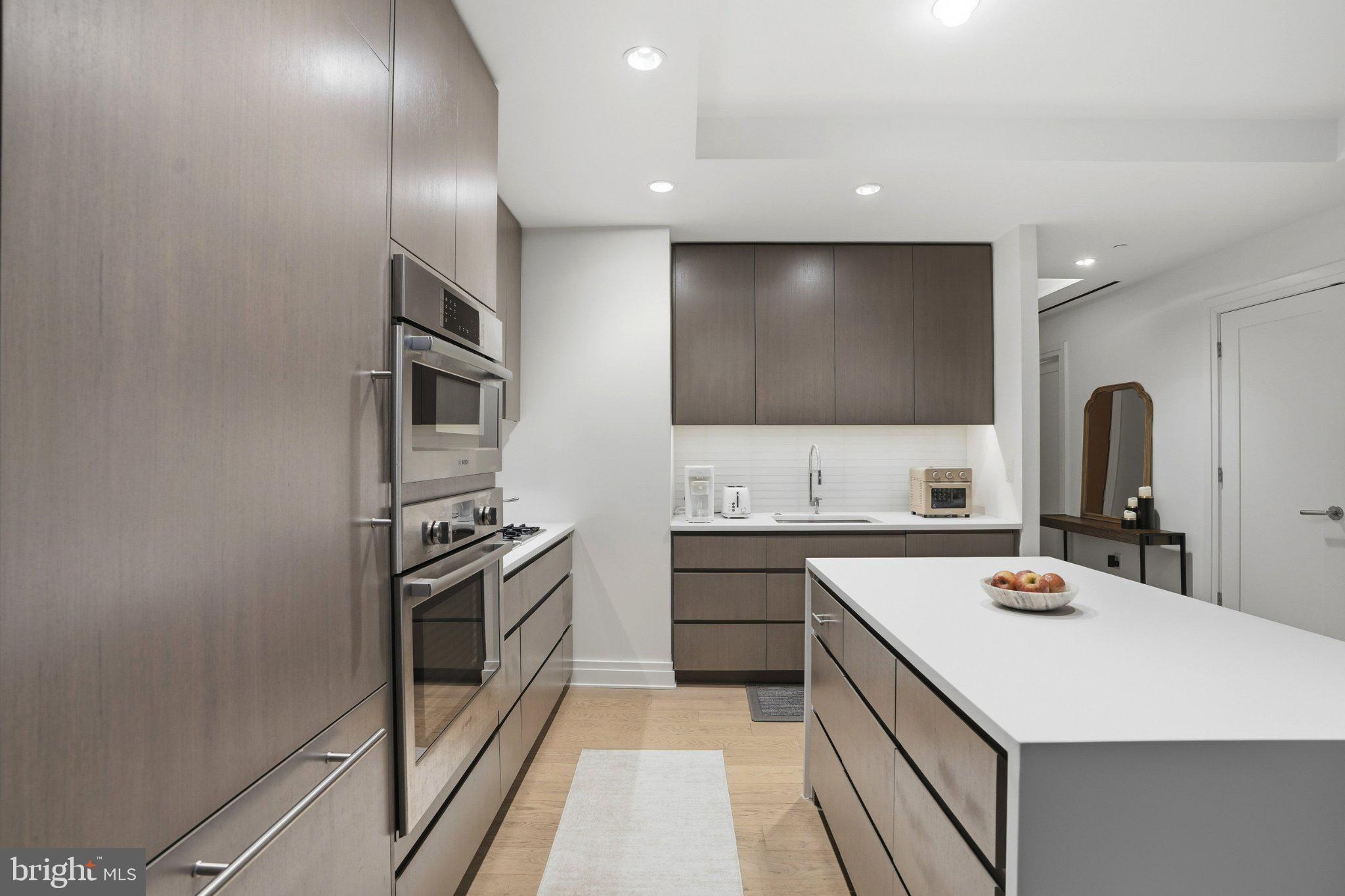 2501 M Street Northwest, Unit 209 Washington, DC 20037 - Photo 9 of 48 a kitchen with stainless steel appliances a sink and a stove top oven