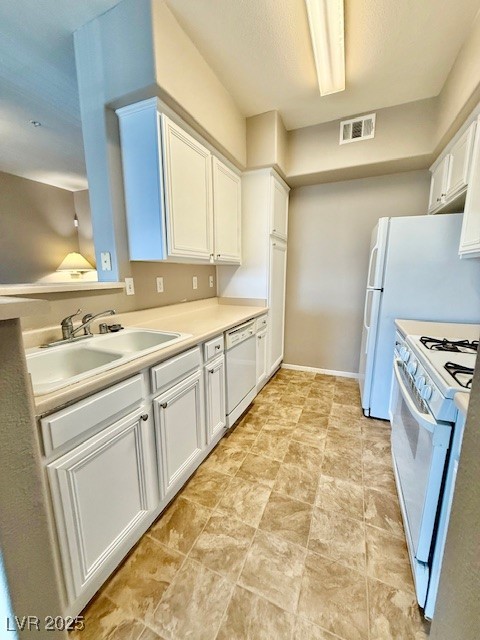 7155 South Durango Drive, Unit 306 Las Vegas, NV 89113 - Photo 2 of 19 Kitchen featuring white appliances, white cabinetry, and light countertops