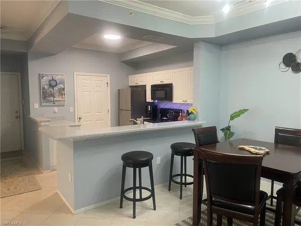 a kitchen with a table chairs refrigerator and microwave