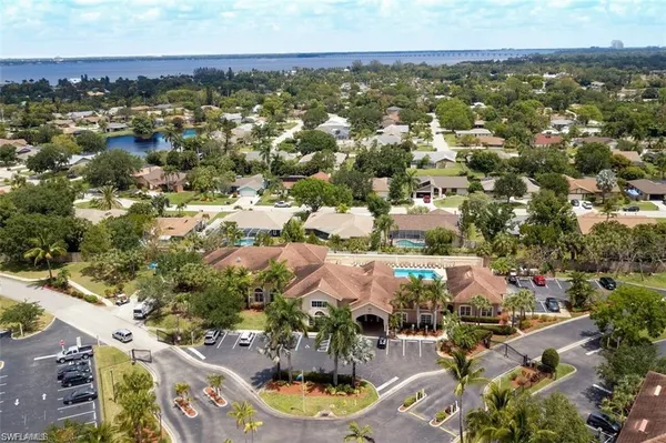a front view of a multi story residential apartment building with yard and outdoor seating
